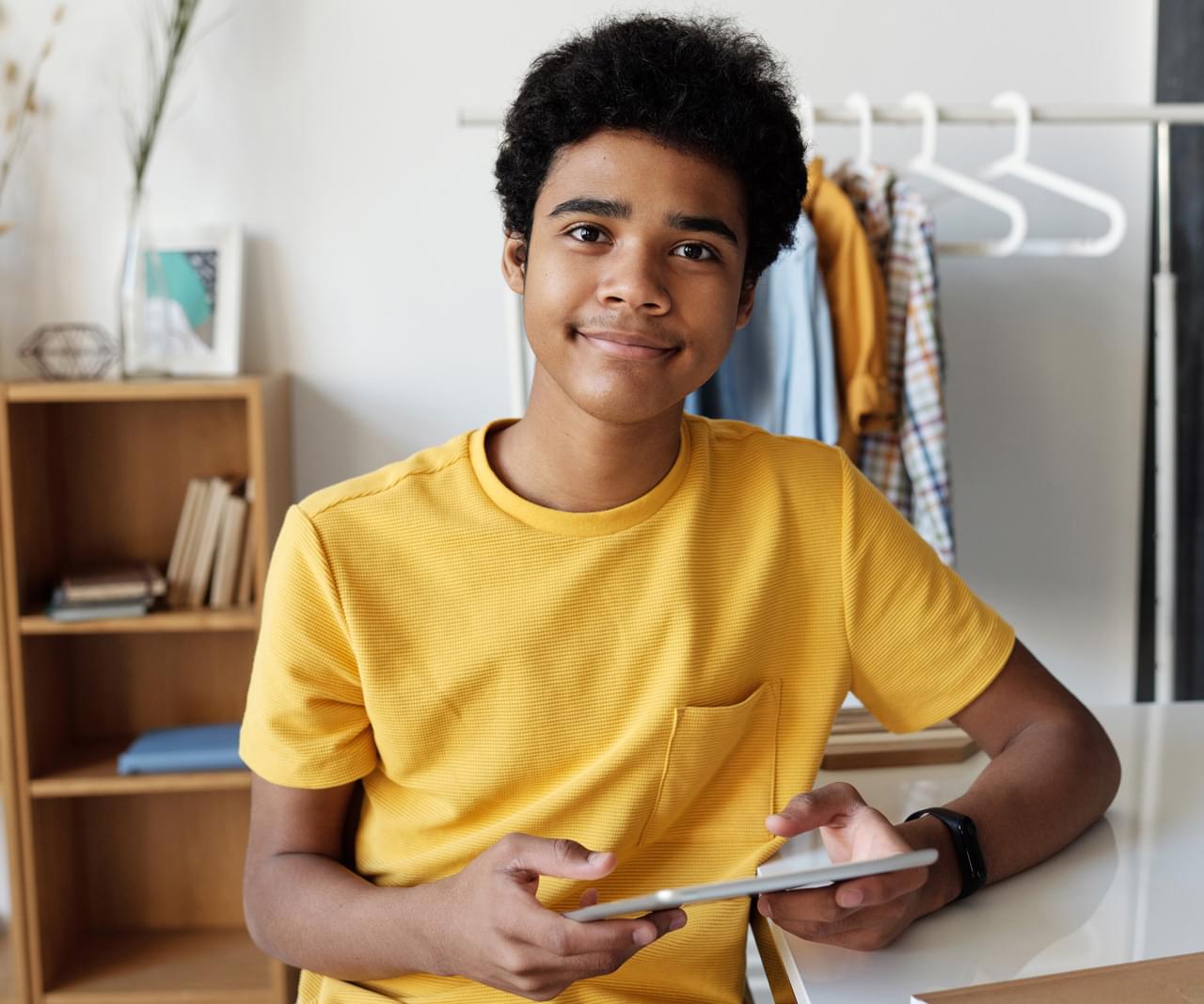 image of a young boy sitting holding a tablet computer